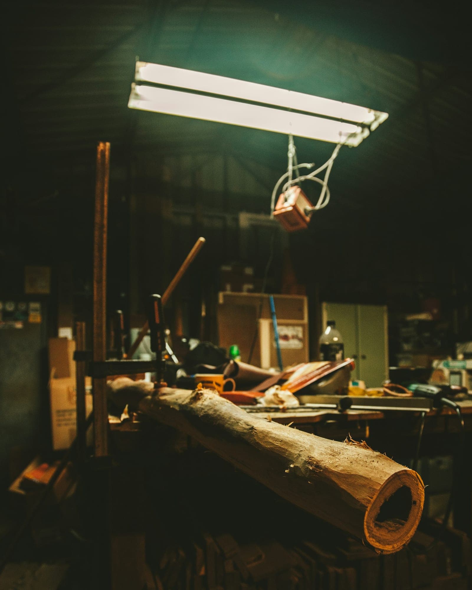Werkbank mit Holzstamm unter Leuchtstofflampe